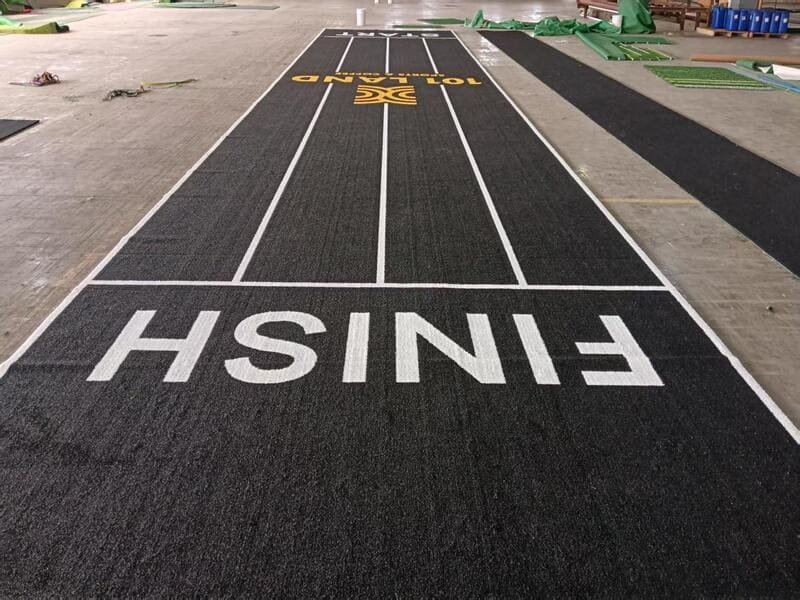 Athlete checking the texture of gym turf with their hand